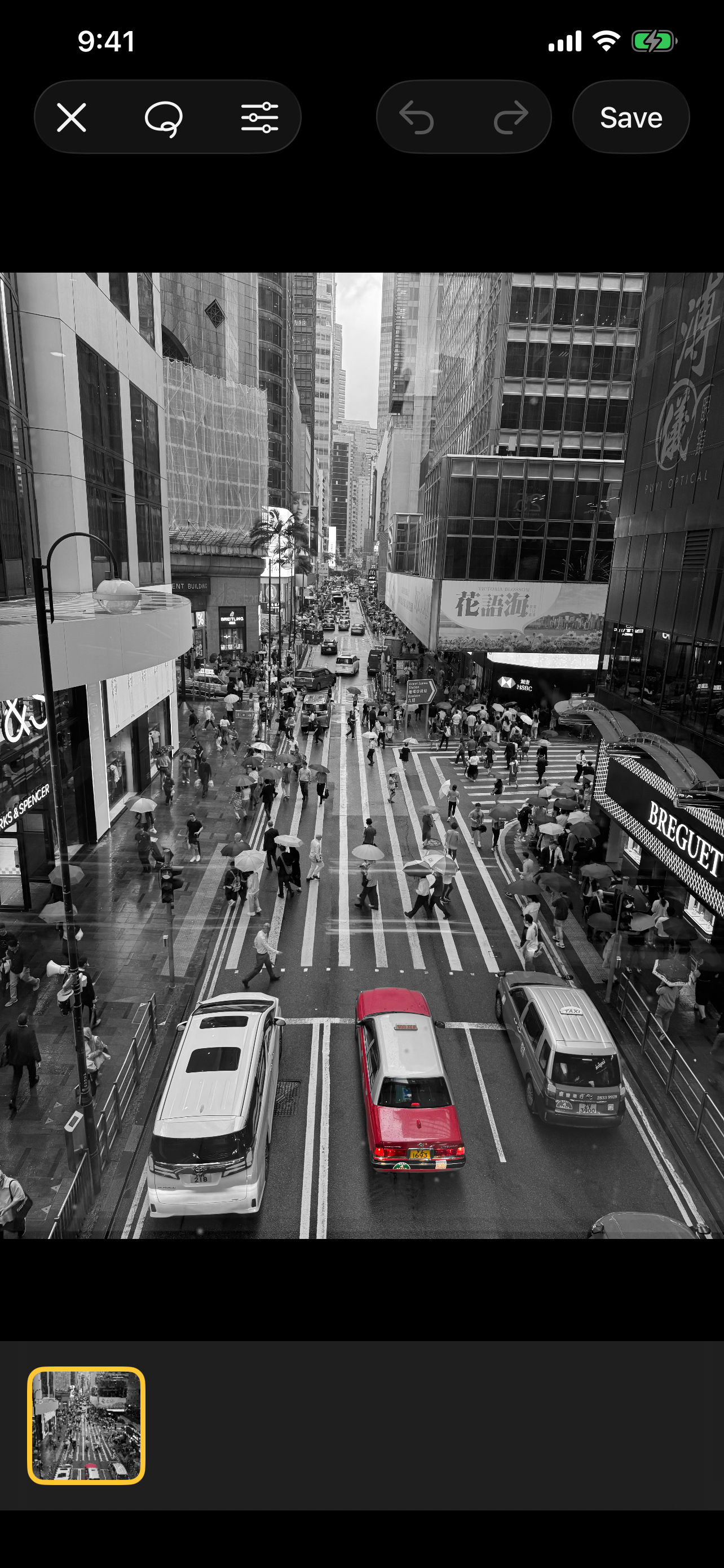 A red taxi kept in color on a grayscale city street